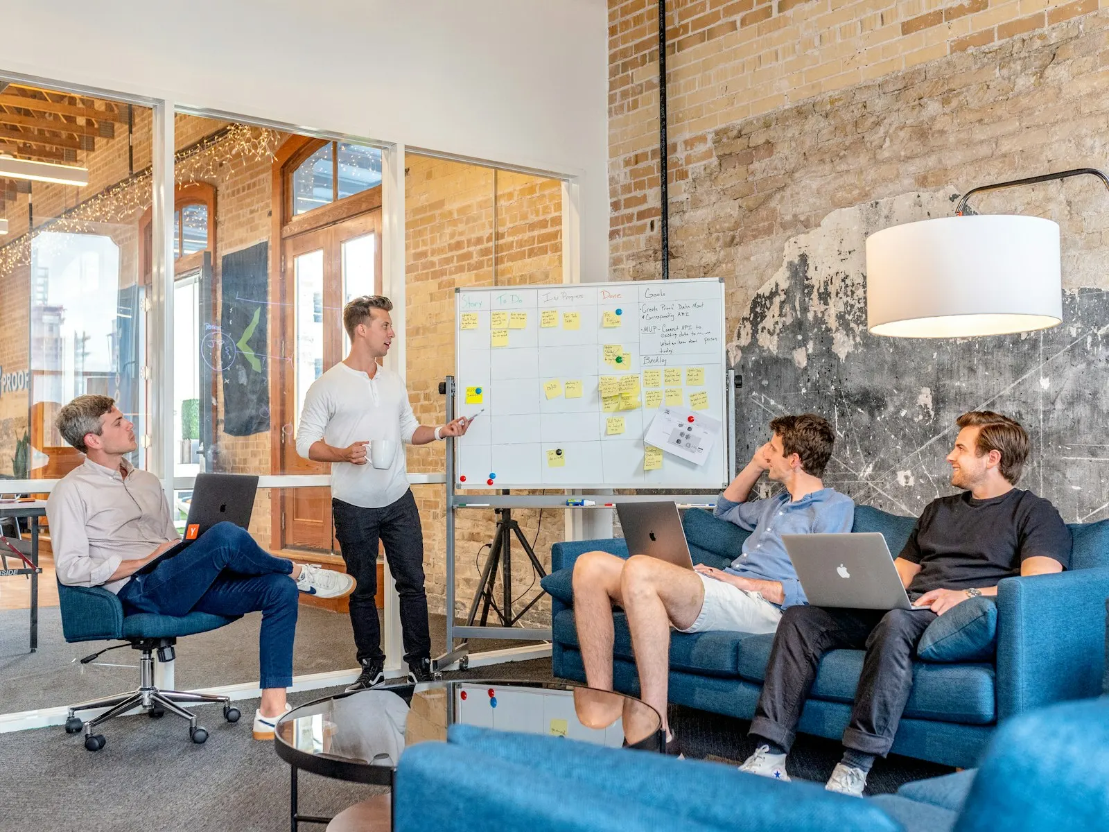 A team gathered around a whiteboard plotting features and user flows with sticky notes.